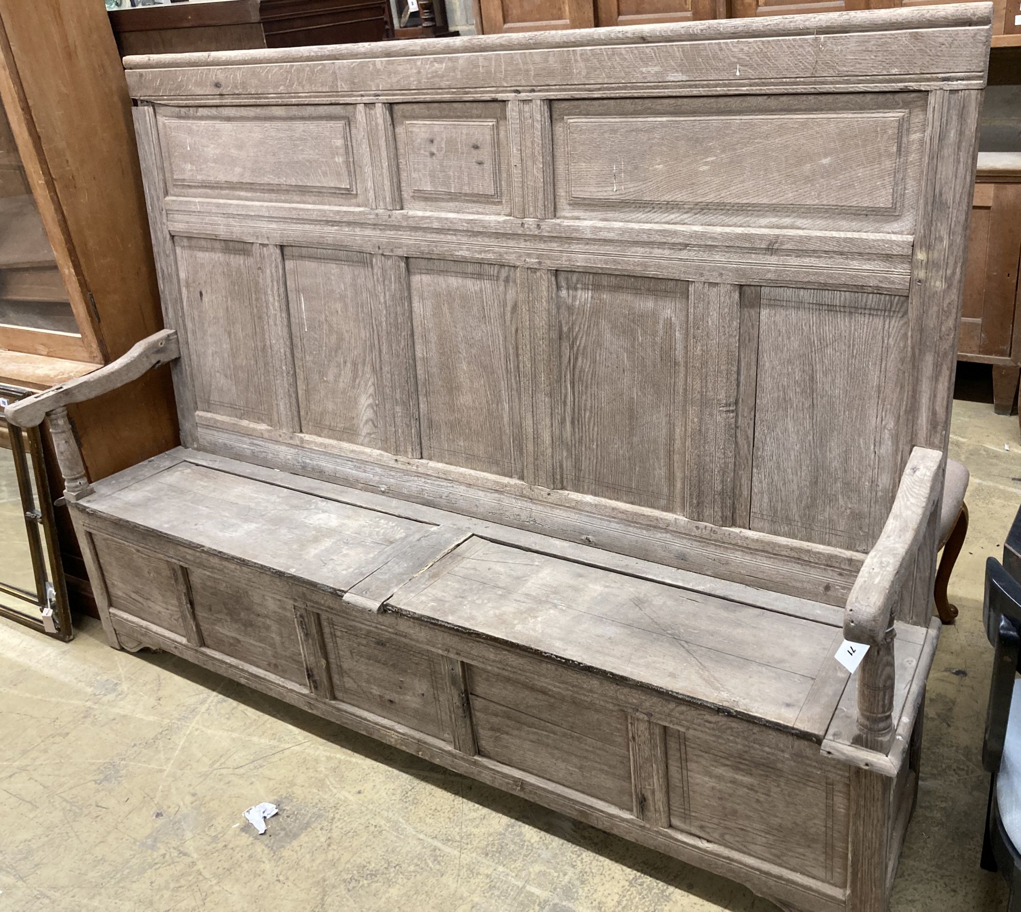 An 18th century bleached oak panelled box seat settle, length 206cm, depth 41cm, height 145cm